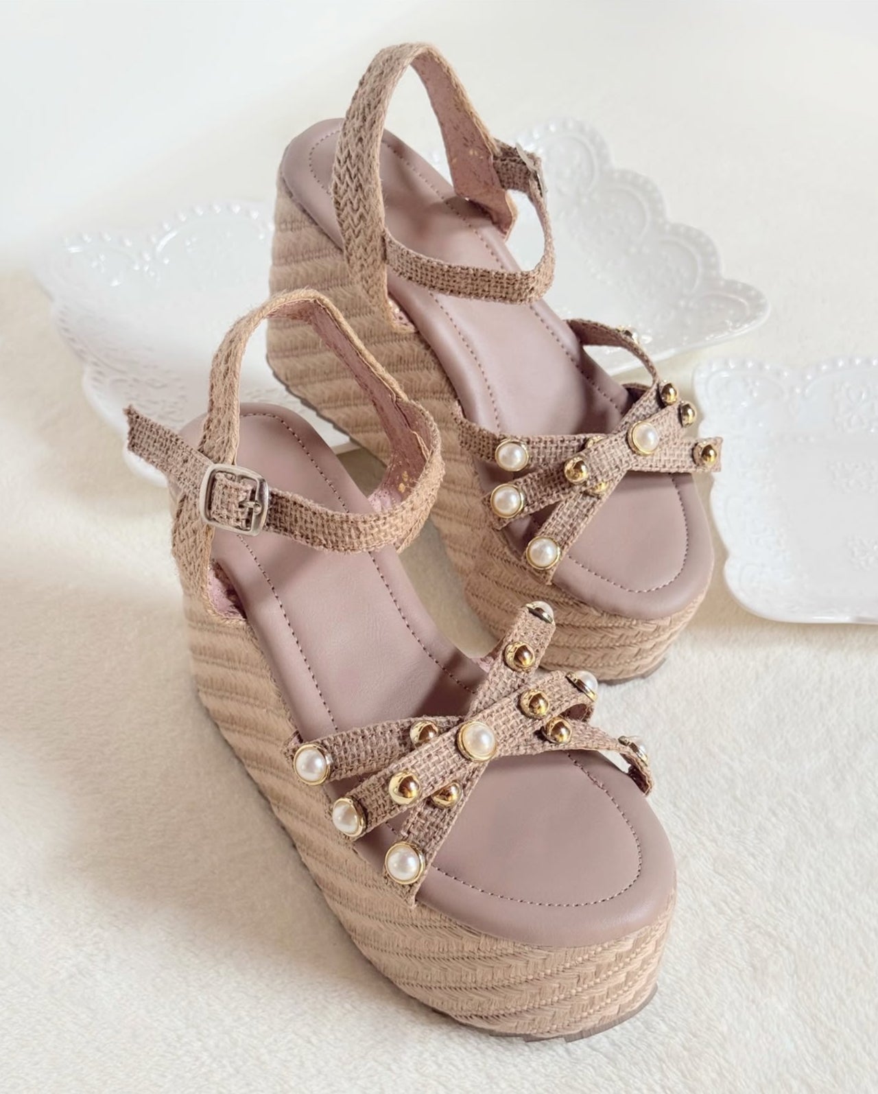 Sandalias con plataforma de 10cm de altura, de color beige con perlas doradas.