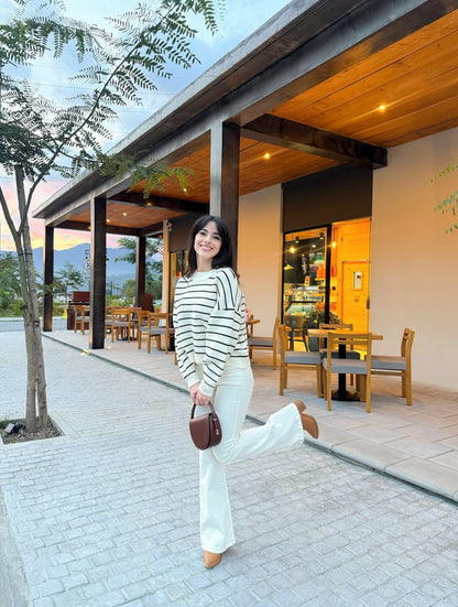Pantalón estilo campana, de lona estrech, color crema.