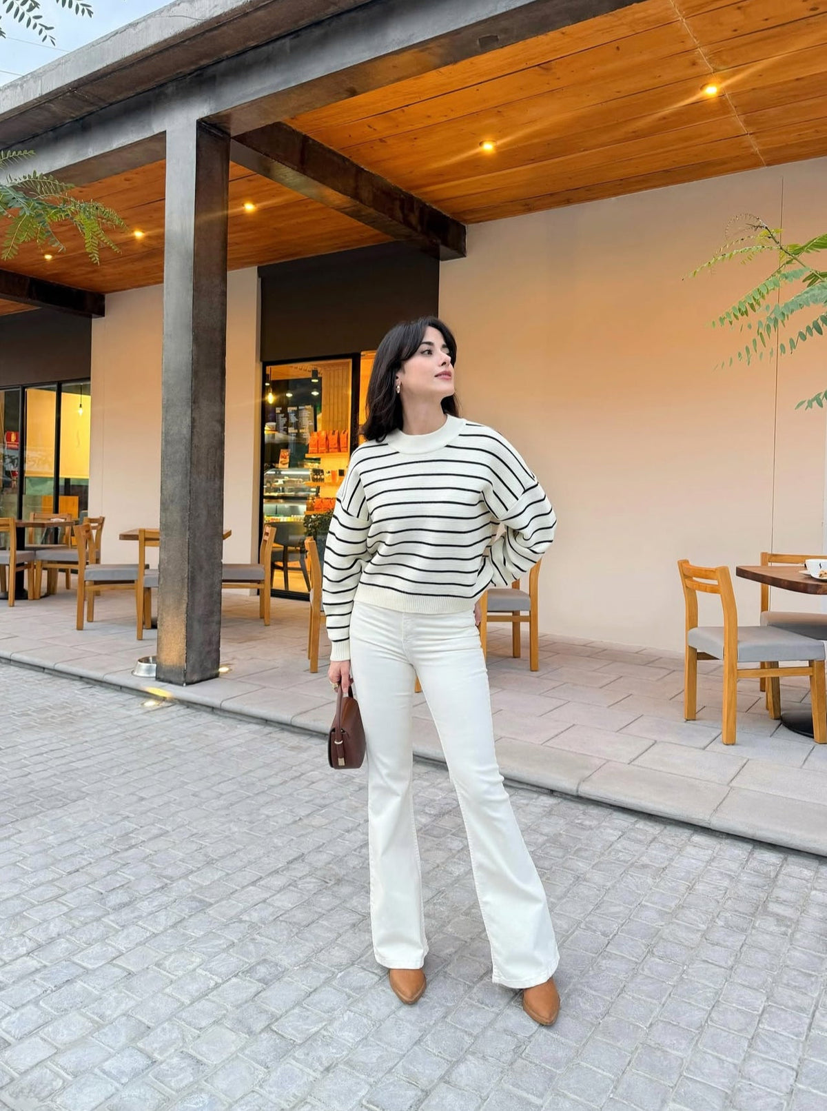 Pantalón estilo campana, de lona estrech, color crema.