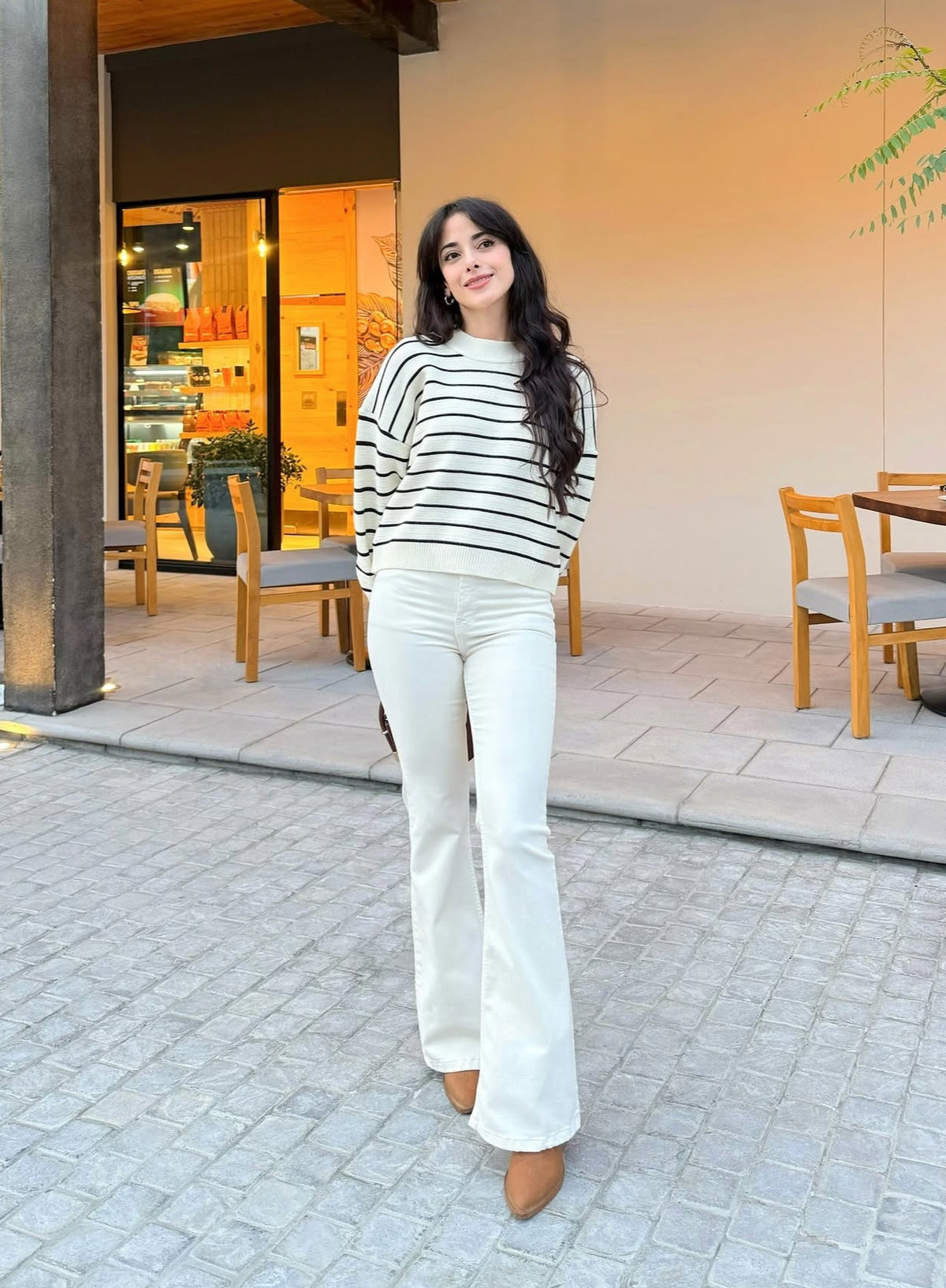 Pantalón estilo campana, de lona estrech, color crema.