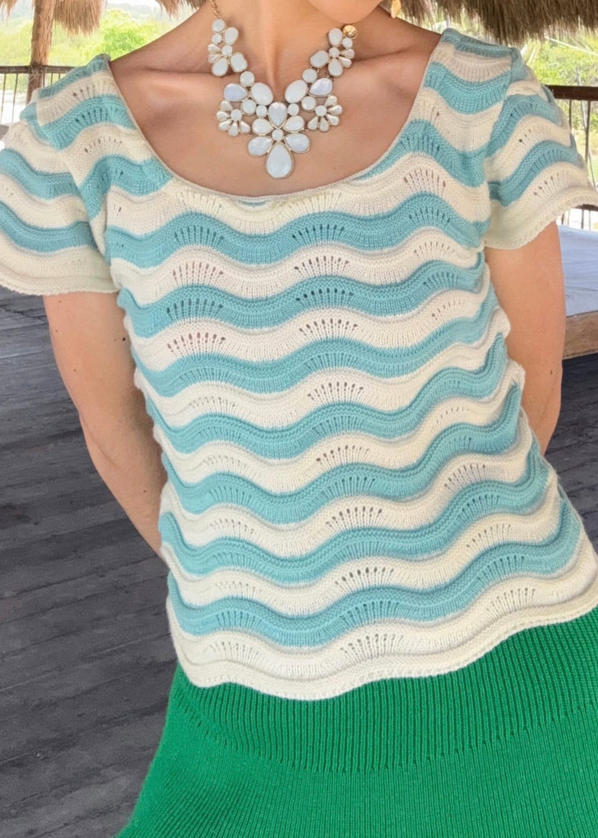 "Celeste Cielo", blusa tejida en tonalidad crema, con detalles asimétricos en celeste claro.
