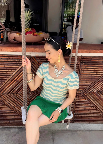 "Celeste Cielo", blusa tejida en tonalidad crema, con detalles asimétricos en celeste claro.
