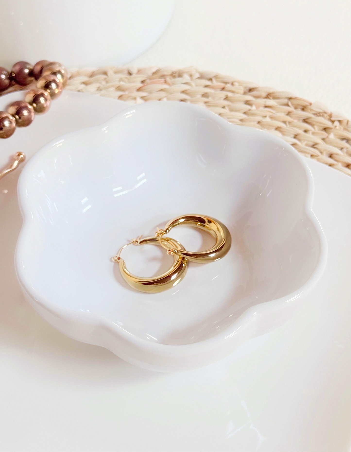 Accesorio tipo aretes, circulares, en tonalidad dorado.