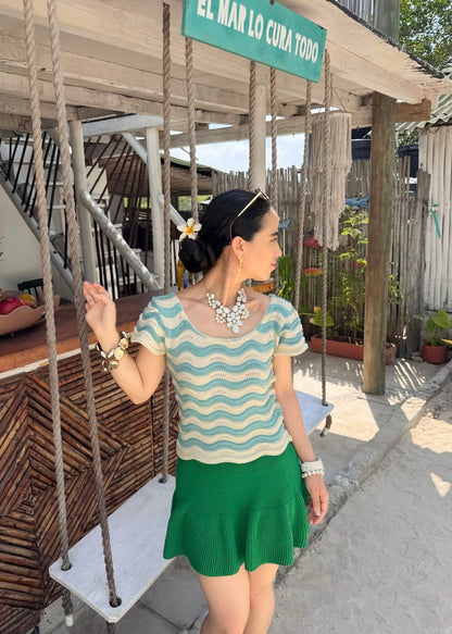 "Celeste Cielo", blusa tejida en tonalidad crema, con detalles asimétricos en celeste claro.