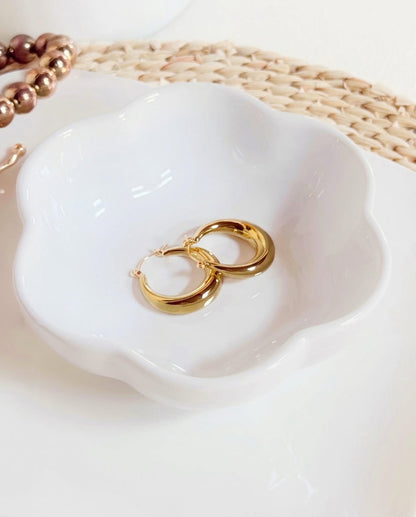 Accesorio tipo aretes, circulares, en tonalidad dorado.